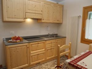 een keuken met houten kasten en een wastafel bij Apartment Cjase Fravins-1 by Interhome in Raveo