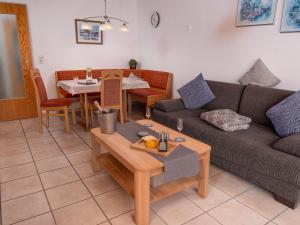 ein Wohnzimmer mit einem Sofa und einem Tisch in der Unterkunft Apartment Kluntje by Interhome in Norddeich