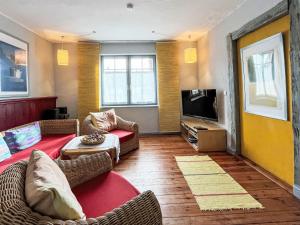 a living room with a couch and a tv at Holiday Home Kapitänshaus Leo by Interhome in Leopoldshagen