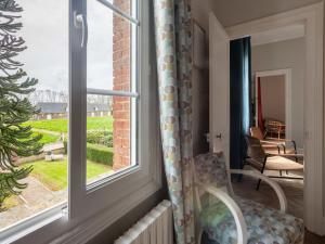 a room with a window with a chair and a table at Holiday Home Le Domaine du Vasouy by Interhome in Colleville