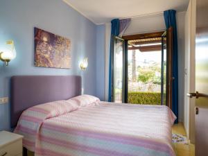 ein blaues Schlafzimmer mit einem Bett und einem Fenster in der Unterkunft Apartment Girasole by Interhome in Termoli