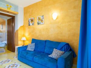 ein blaues Sofa im Wohnzimmer mit gelber Wand in der Unterkunft Apartment Girasole by Interhome in Termoli