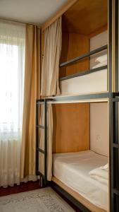 two bunk beds in a room with a window at Ayla Hostel in Osh