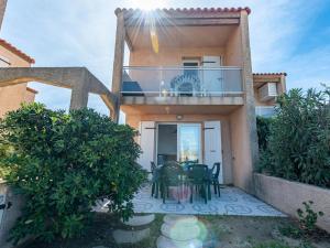 una casa con balcone arredato con tavolo e sedie di Holiday Home Bastides de la Mer-1 by Interhome a Le Barcarès