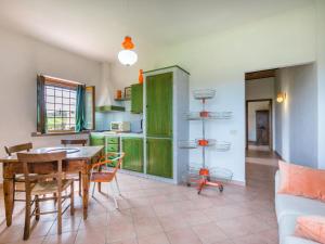 サン・ジミニャーノにあるApartment Casa Renai a San Gimignano-3 by Interhomeのキッチン(緑のキャビネット、テーブル、椅子付)