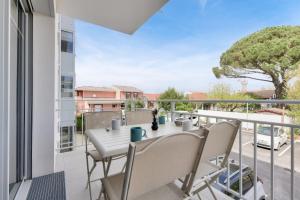 Un patio con una mesa y sillas en un balcón. en À 500m de la plage de la Jetée, appartement pour 4, en Andernos-les-Bains