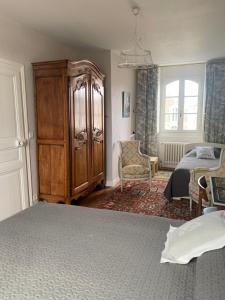 a bedroom with a bed and a dresser and a bed and a room with at Villa Hébert in Saint Malo