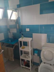 La salle de bains est pourvue de toilettes blanches et de carrelage bleu et blanc. dans l'établissement Canarian Havaii en Faluas, à Playa del Ingles
