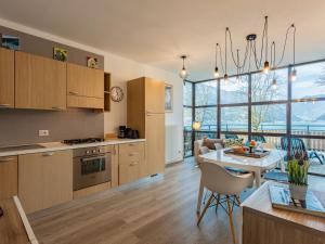 a kitchen and living room with a table and a dining room at Apartment Superior-1 by Interhome in Mezzolago