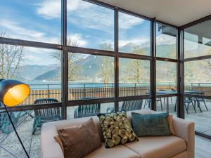a living room with a couch and a large window at Apartment Superior-1 by Interhome in Mezzolago