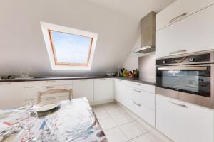 eine Küche mit weißen Schränken und einem Fenster in der Unterkunft Appart pour 6 - 850m des plages Rohu & Govelins in Saint-Gildas-de-Rhuys + 9 Fotos