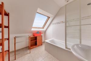 ein Badezimmer mit einer weißen Badewanne und einem Waschbecken in der Unterkunft Appart pour 6 - 850m des plages Rohu & Govelins in Saint-Gildas-de-Rhuys