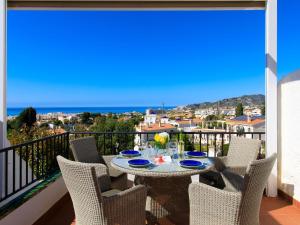 a balcony with a table and chairs with a view of the ocean at Apartment Limoneros by Interhome in Nerja