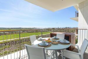 a table and chairs on a balcony with a view at Apartment Rising Sun By Dalma Portuguesa in Armação de Pêra