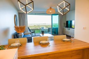 阿爾馬桑－德佩拉的住宿－Apartment Rising Sun By Dalma Portuguesa，用餐室以及带桌椅的起居室。