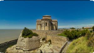 een oud gebouw bovenop een stenen muur bij Joli appartement in Cozes