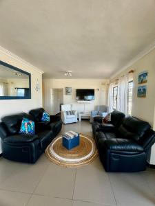 una sala de estar con 2 sofás de cuero y una mesa. en Irina House&BreakerView, en Ramsgate