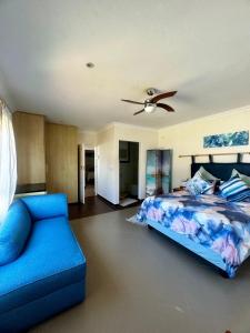um quarto com uma cama azul e um sofá em Irina House&BreakerView em Ramsgate