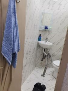 a white bathroom with a sink and a toilet at Eminera Hostels Baku in Baku