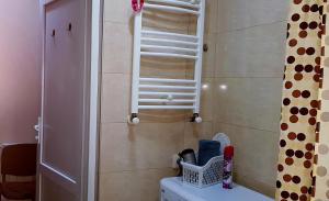 Baño con escalera de toallas sobre un aseo en tamunas apartment en Tiflis