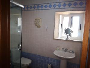 ein Bad mit einem Waschbecken, einem WC und einem Fenster in der Unterkunft Shakti Rio Mino in San Bartolomé