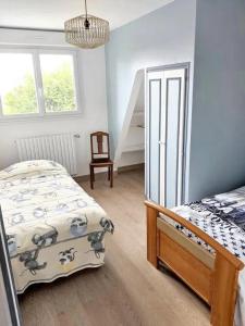 een slaapkamer met een bed en een stoel erin bij Maison de 6 chambres avec jardin amenage a Donville les Bains a 1 km de la plage in Donville-les-Bains
