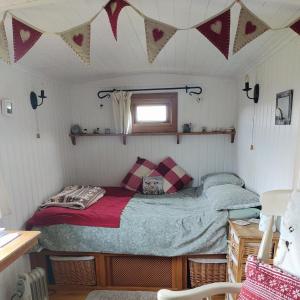 sypialnia z łóżkiem w małym pokoju w obiekcie Shepherd's Hut Bilsdale w mieście Chop Gate