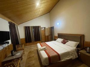 a bedroom with a large bed and a television at heavens retreat manali in Manāli