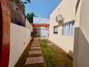 an alley between two white buildings with grass between them at AP com cozinha de uso exclusivo in Sorriso
