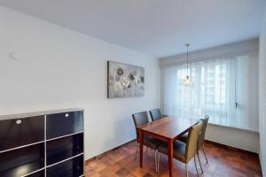 a dining room with a wooden table and chairs at Bright 1 bedroom flat in the city centre (Greenyard 2) in Zurich