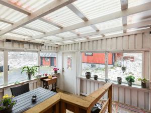 a screened in porch with a table and windows at Holiday Home Skjutsmåla - B in Olofström