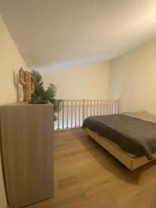 Schlafzimmer mit einem Bett und Holzboden in der Unterkunft Appartement au Parc de la Grange in Jard-sur-Mer