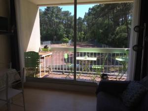 einen Blick aus dem Fenster eines Balkons mit einem Tisch in der Unterkunft Appartement au Parc de la Grange in Jard-sur-Mer