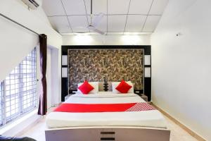 - une chambre avec un grand lit et des oreillers rouges dans l'établissement OYO Nova Dumas Homestay, à Surate