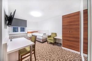 Pokój hotelowy z łóżkiem i biurkiem w obiekcie Pension Delicato w mieście Waidhaus