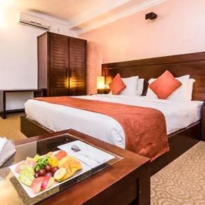 Zimmer mit einem Bett und einem Tablett mit Speisen in der Unterkunft Suneetha Hotel in Polonnaruwa