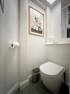 a bathroom with a toilet and a picture on the wall at Wades Place E14 in London