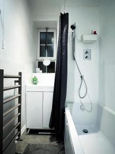 a white bathroom with a shower and a sink at Wades Place E14 in London