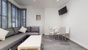 een woonkamer met een bank en een tafel bij LONDON STAY Flats in Londen