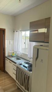 a kitchen with a stove top oven next to a window at AP 2 quartos e cozinha de uso exclusivo in Sorriso