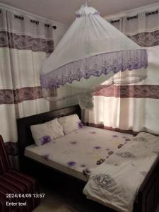 a small bed with a canopy in a bedroom at A 4G LODGE in Mugumu