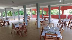 a dining room with tables and chairs and windows at REFUGE du MONT AGOU 