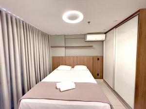 - une chambre avec 2 lits et des serviettes dans l'établissement Brookfield Towers Marron Sevem - Jardim Goiás, à Goiânia