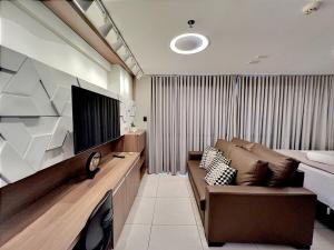 Il comprend un salon doté d'un canapé et d'une télévision à écran plat. dans l'établissement Brookfield Towers Marron Sevem - Jardim Goiás, à Goiânia
