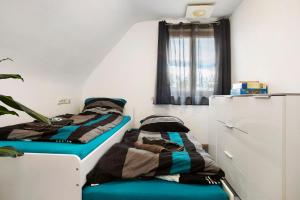 dwa łóżka siedzące obok siebie w pokoju w obiekcie Zäh w mieście Meckenbeuren