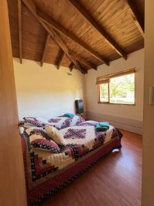 ein Schlafzimmer mit einem Bett in einem Zimmer in der Unterkunft Cabaña Cordón Situación in Trevelín
