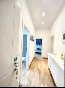 a bathroom with white walls and a wooden floor at 5 bedrooms apartement at Napoli 500 m away from the beach with sea view and wifi in Naples