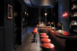 a bar with orange stools in a black room at TORTUE Hamburg in Hamburg