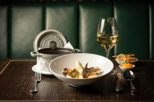 a table with a bowl of food and a glass of wine at TORTUE Hamburg in Hamburg