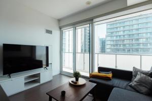 a living room with a couch and a large window at Luxury Condo w/Fascinating View&Free Parking in Toronto